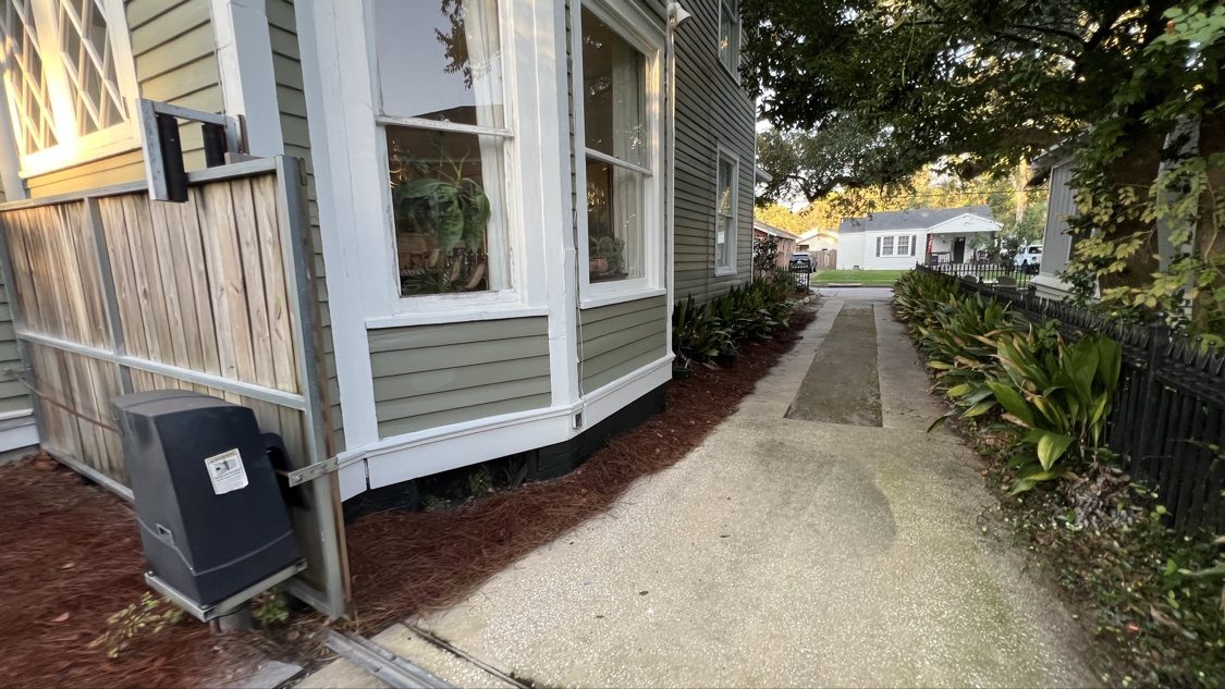 Colored pine straw along the side of a house