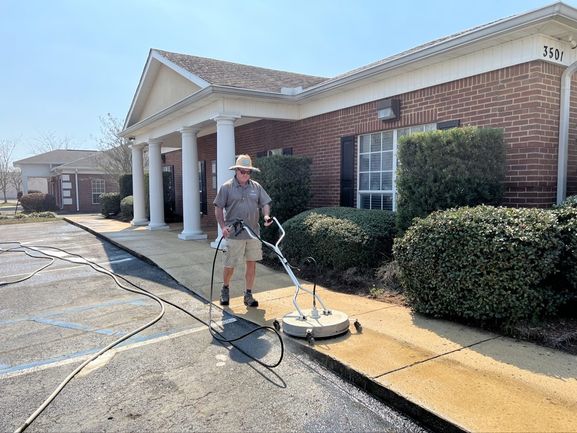 Chad running the surface cleaner on a commercial sidewalk