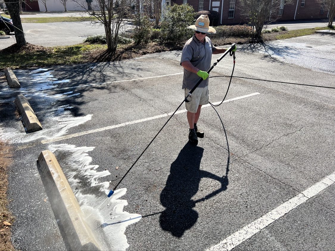 Pressure washing a parking lot curb line