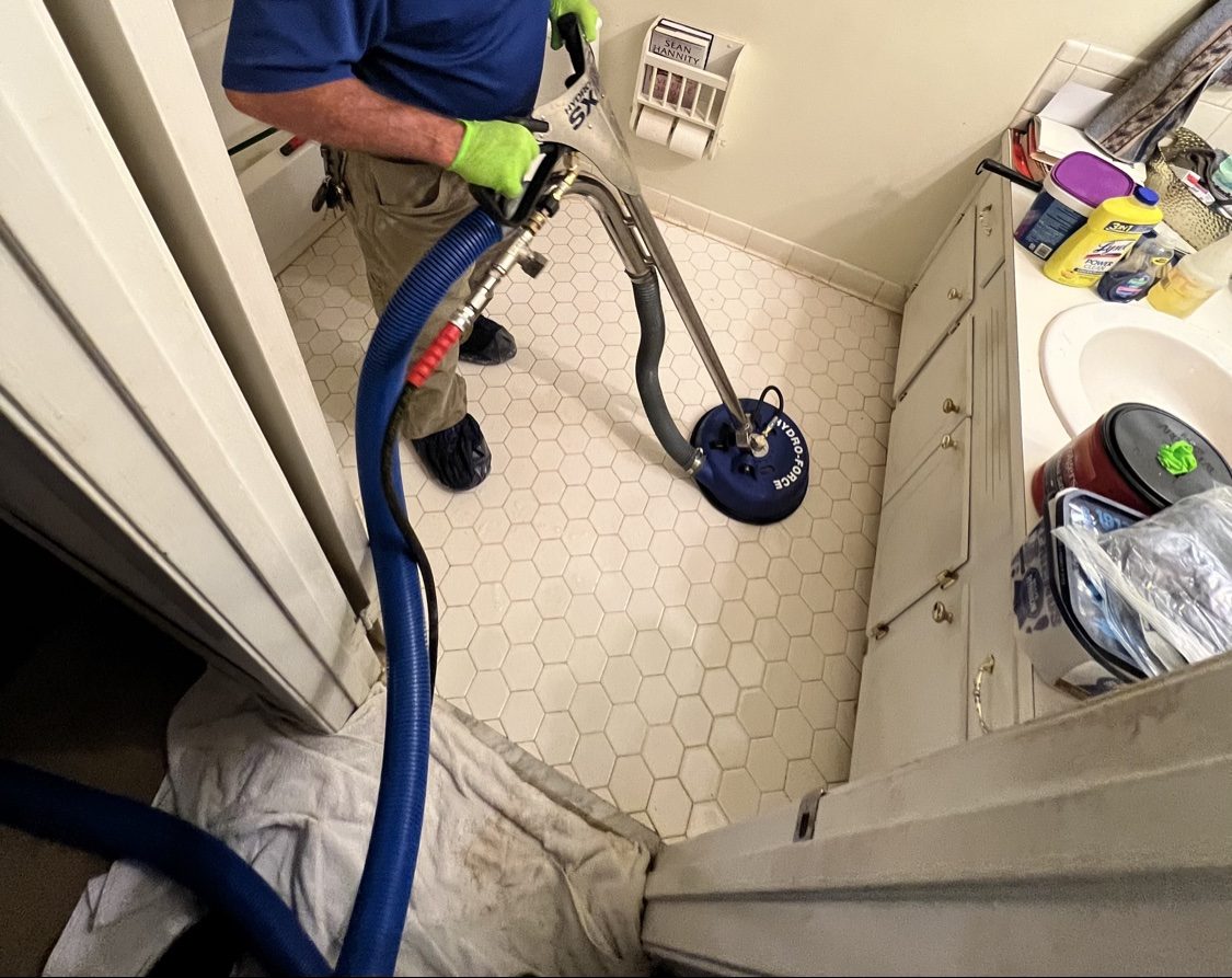Rotary tile cleaner restoring a bathroom floor