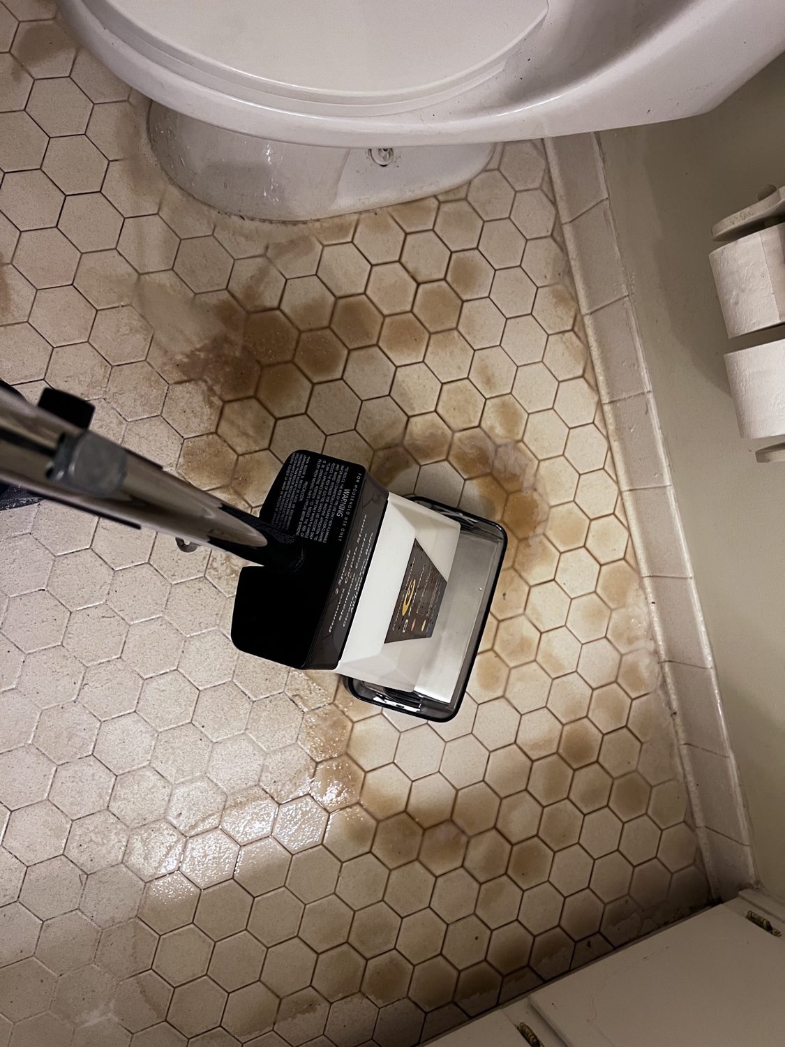 Dirty bathroom tile floor before grout cleaning