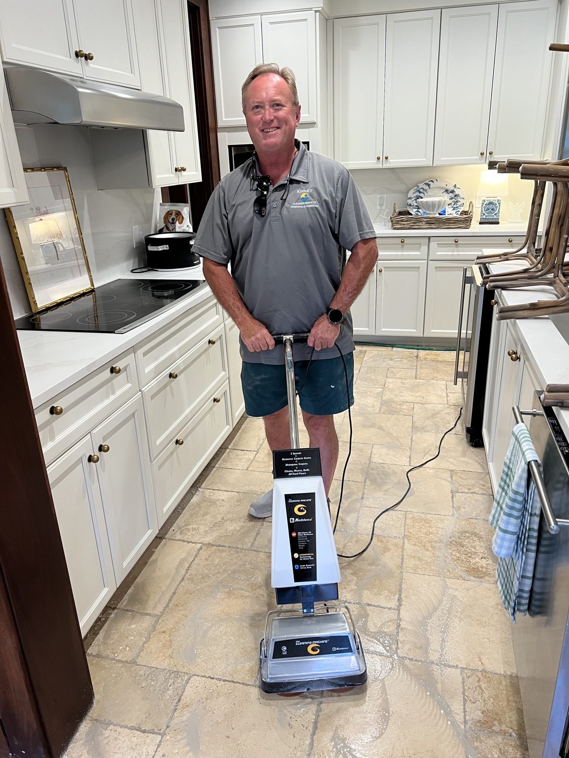 Floor machine scrubbing a kitchen tile floor